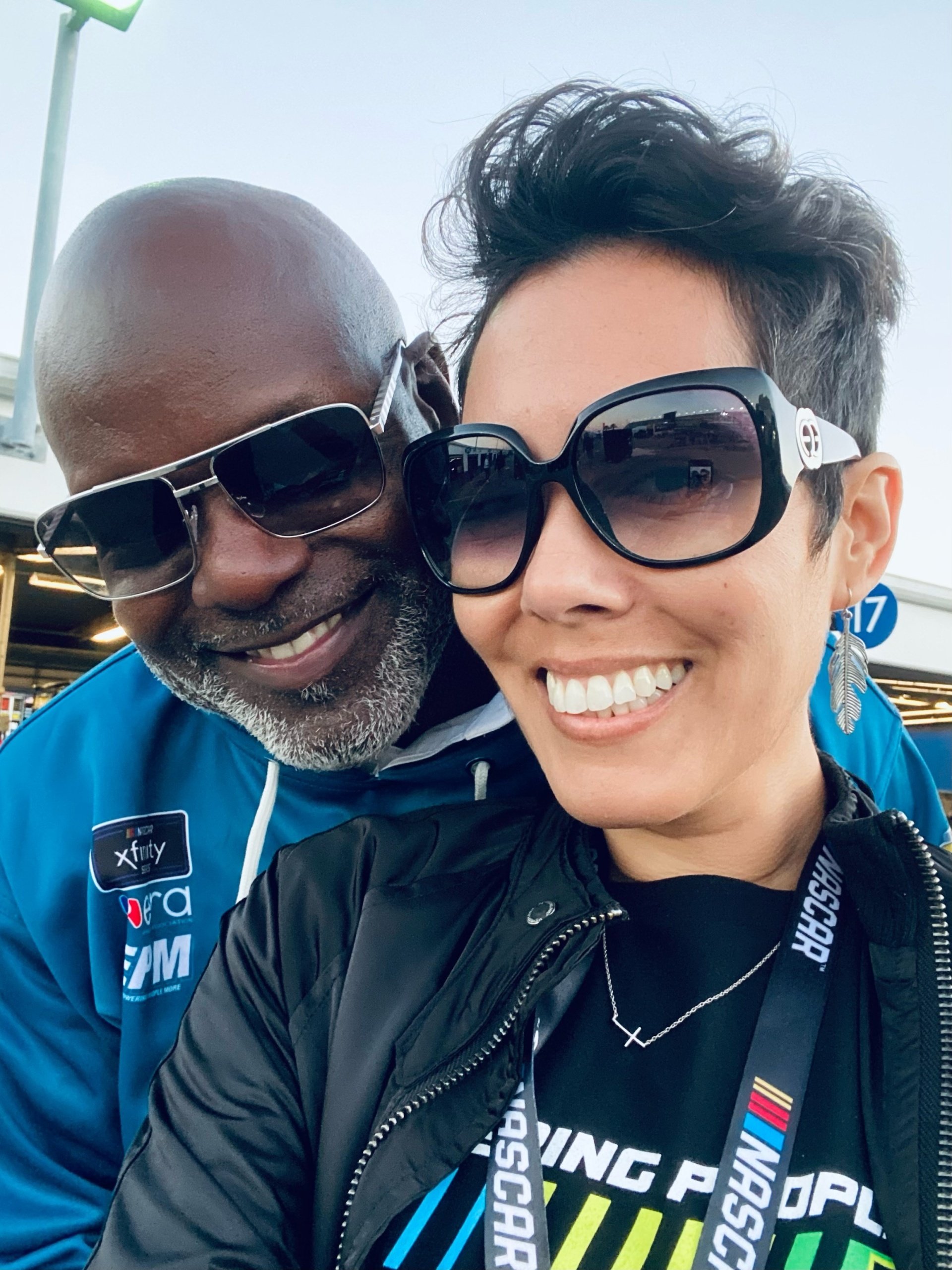 Dalila at a racetrack networking event with a driver