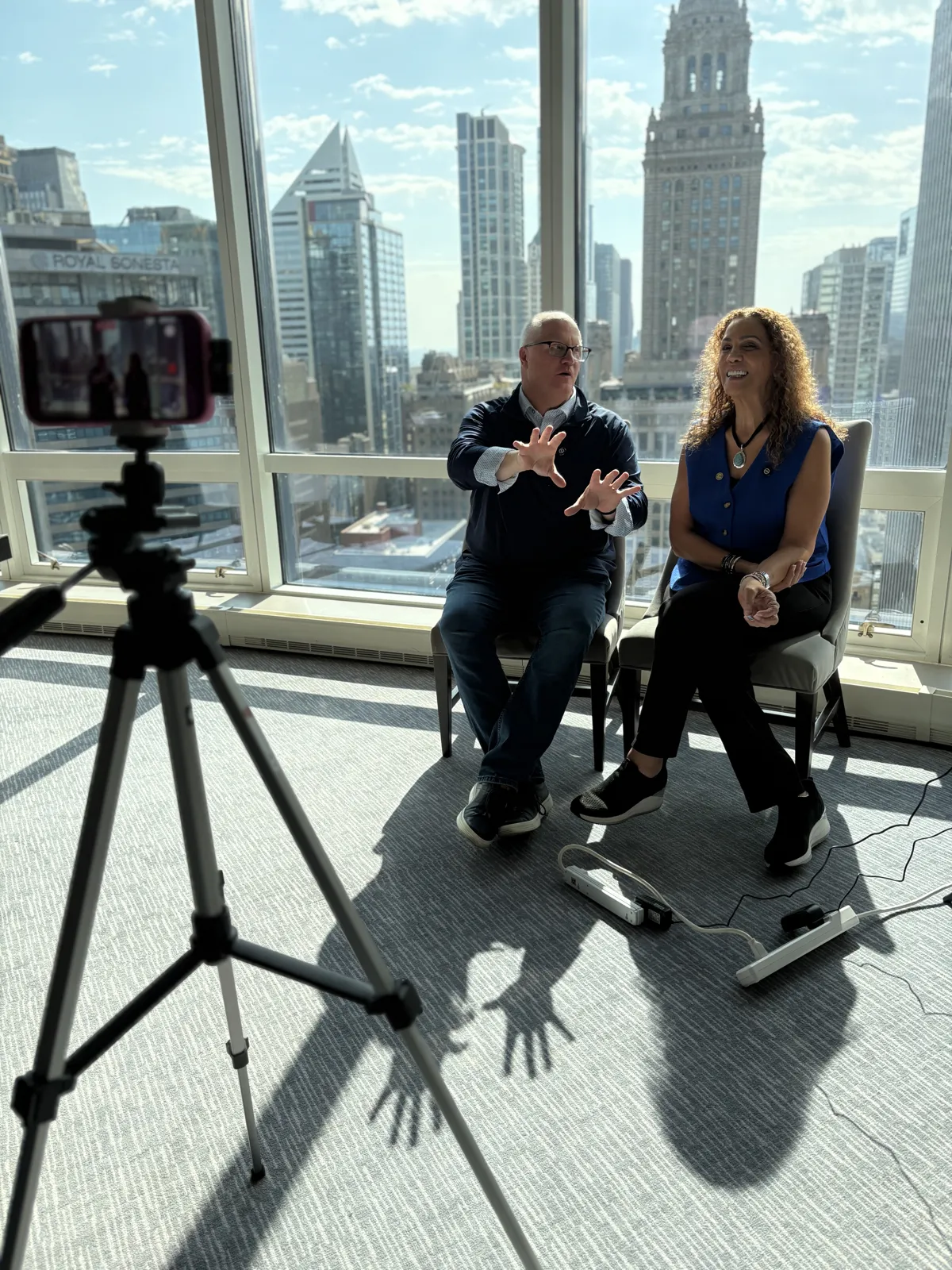 Filming an interview in front of floor-to-ceiling windows